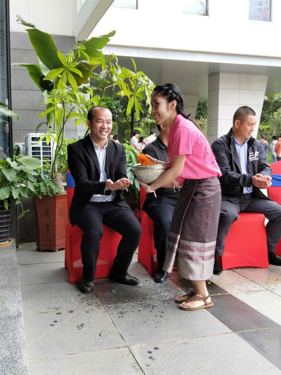 老撾駐廣西留學(xué)生代表將浸有花瓣的香水灑客人的手上，表示對嘉賓的美好祝福（圖一）
