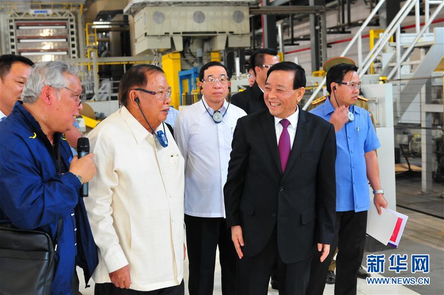 3月10日，在老撾沙灣拿吉省車(chē)邦縣，老撾人民革命黨中央總書(shū)記、國(guó)家主席本揚(yáng)（左二）在山東太陽(yáng)紙業(yè)股份有限公司董事長(zhǎng)李洪信（右二）的陪同下視察公司。 新華社記者章建華攝